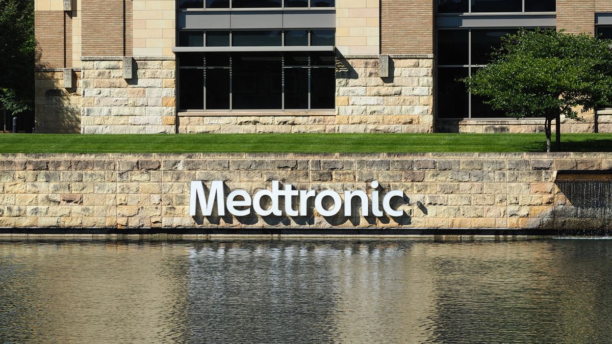 A sign on a rock wall over a lake says 'Medtronic'